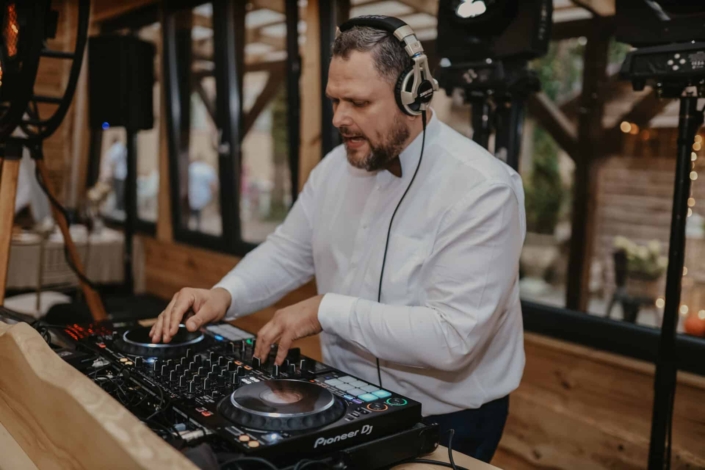 service-dj-real-1 DJ Szumny miksujący muzykę przy profesjonalnej konsolecie
